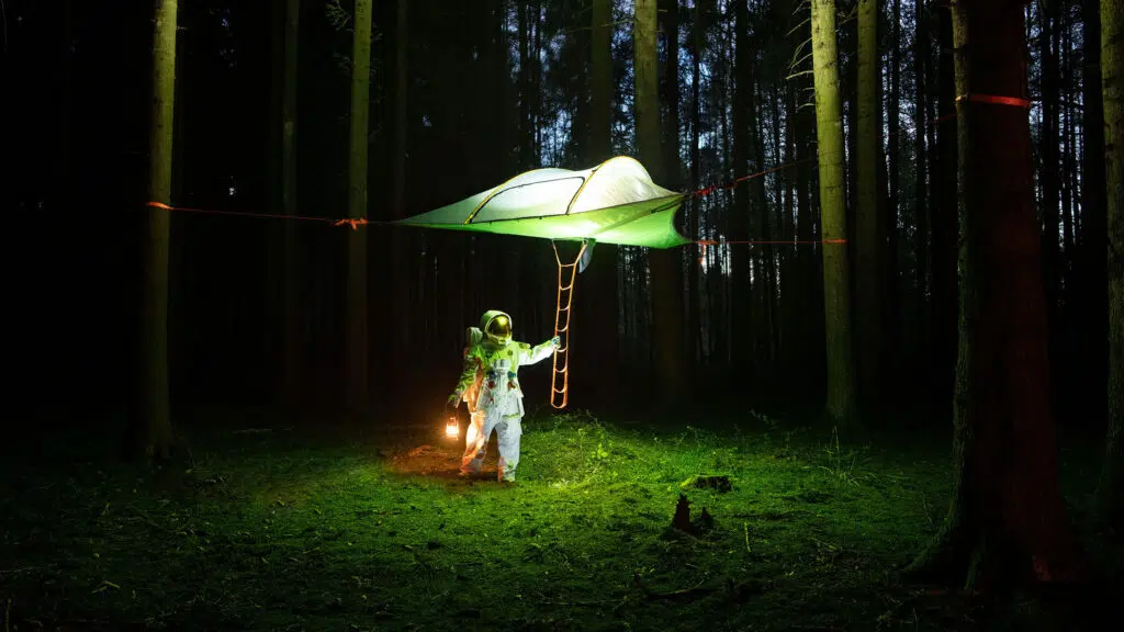astronaut in wald mit zelt erklärungsvideo
