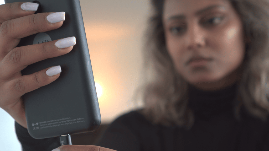 frau mit handy und licht imhintergrud greenlight videoproduktionen schweiz erlärvideo und kurzfilme