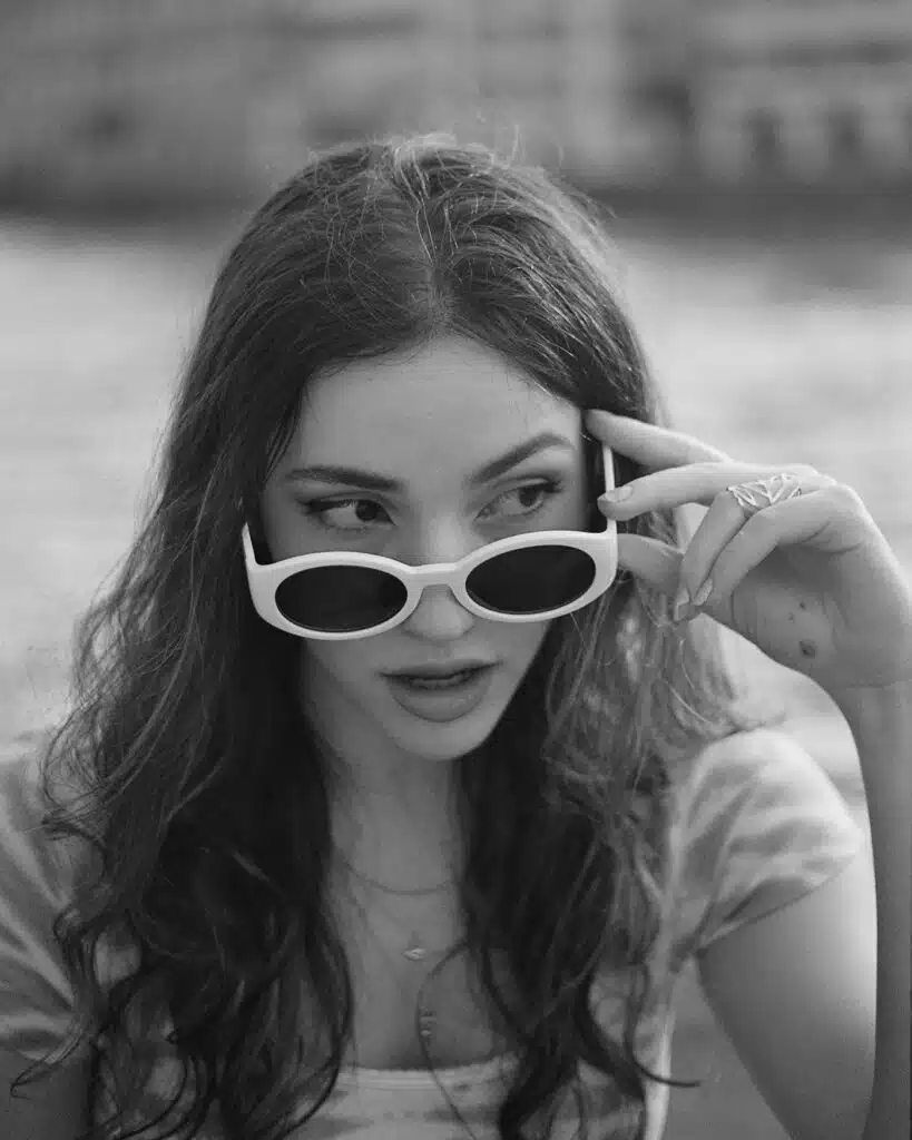 junge frau schaut über ihre sonnenbrille schwarz weiss B&W analog fotografie