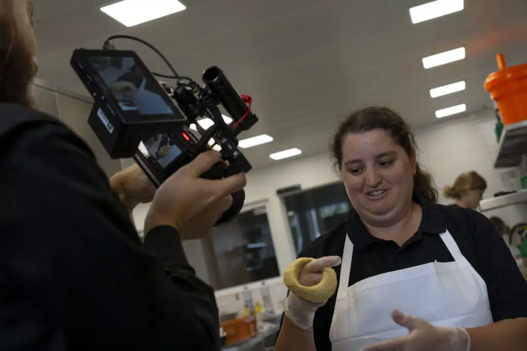 Frau schwingt dounat. passt zum Thema werbevideo erstellen.