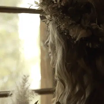 Frau mit Blumenkranz und Hochzeitsstrauss an schweizerischem Fenster
